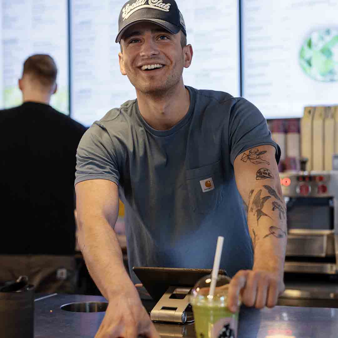 Smiling employee from Joe & The Juice in Frederiksberg.